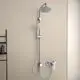 Duschsystem von Ideal Standard mit overhead Dusche und Handbrause, Chromoberfläche, montiert an einer hellen Wand, und einem dazugehörigen Verstellmechanismus.